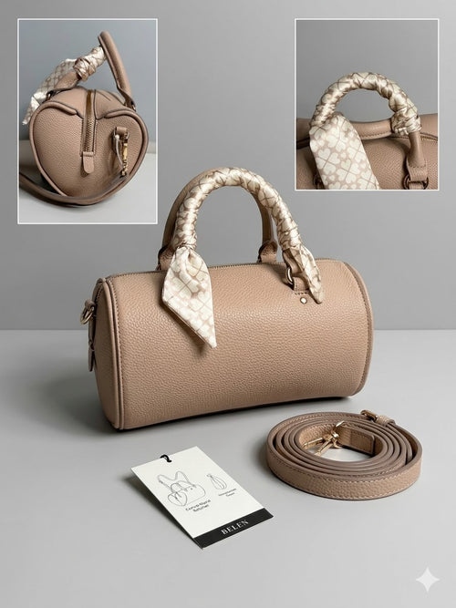 Beige handbag with decorative handles on a gray background