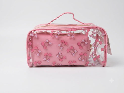 Pink toiletry bag with bow pattern on a light gray background